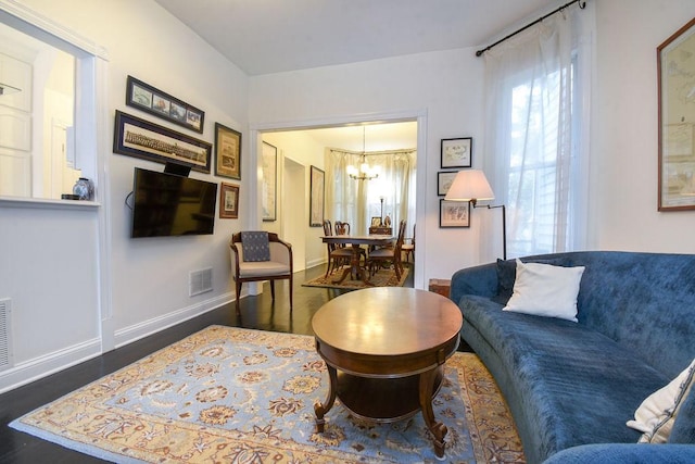 living room featuring dark hardwood / wood-style floors and a notable chandelier