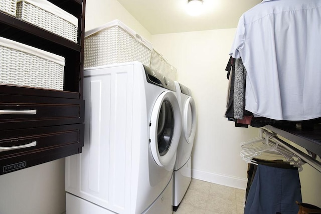 laundry area with light tile patterned flooring and washing machine and clothes dryer