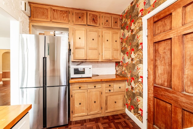 kitchen with wooden counters, stainless steel fridge, and dark parquet floors