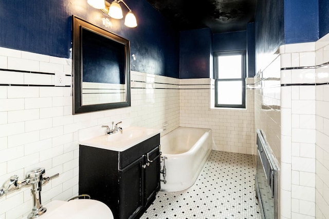 bathroom featuring tile patterned floors, vanity, tile walls, and a tub