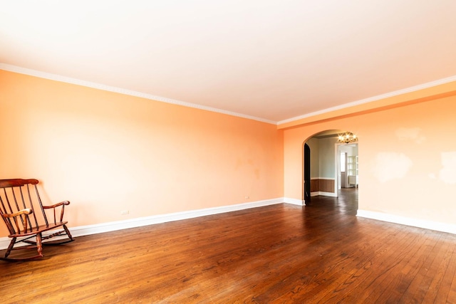 empty room featuring wood-type flooring and crown molding