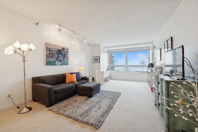 carpeted living room featuring rail lighting and a textured ceiling