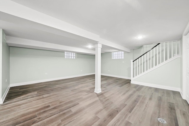 basement with stairway, baseboards, and wood finished floors