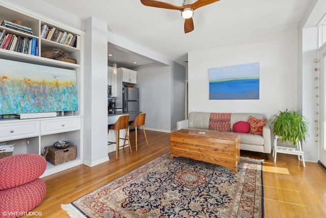 living room featuring ceiling fan and light hardwood / wood-style floors