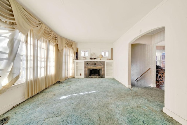 unfurnished living room with a fireplace, ornamental molding, and carpet flooring