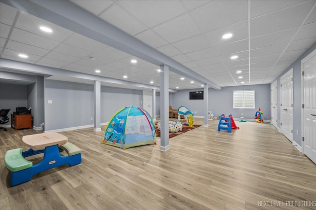 game room featuring wood-type flooring and a paneled ceiling