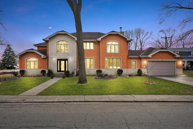 front facade featuring a garage and a yard