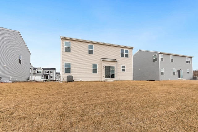 back of property with cooling unit and a yard