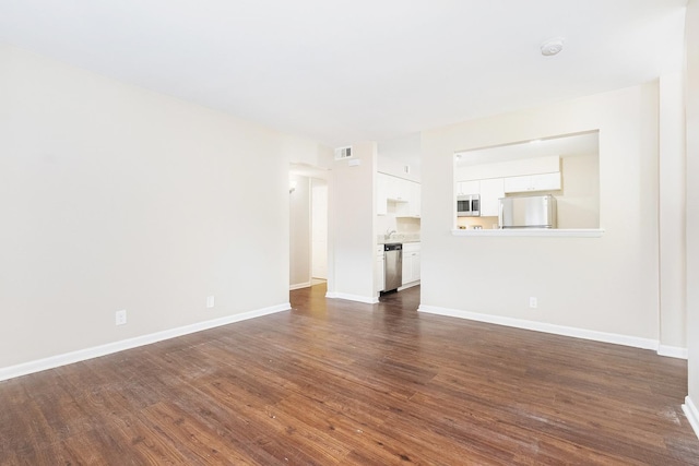 unfurnished living room with dark hardwood / wood-style flooring