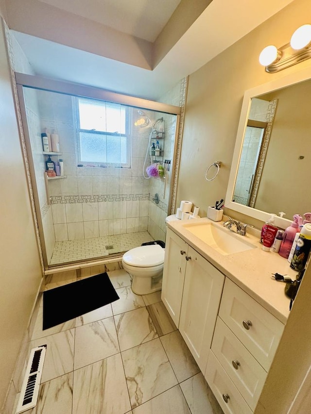 bathroom featuring vanity, walk in shower, and toilet