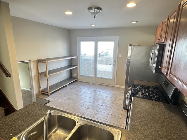 kitchen with light tile patterned flooring, stainless steel appliances, and sink