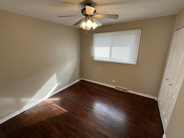 unfurnished bedroom with dark hardwood / wood-style floors, a closet, and ceiling fan