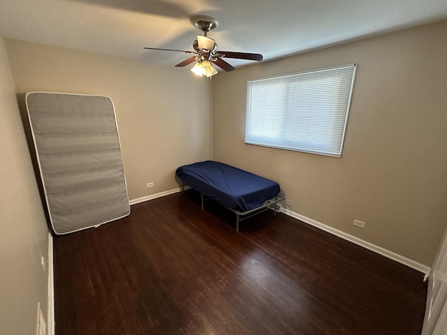 unfurnished bedroom featuring ceiling fan and dark hardwood / wood-style flooring