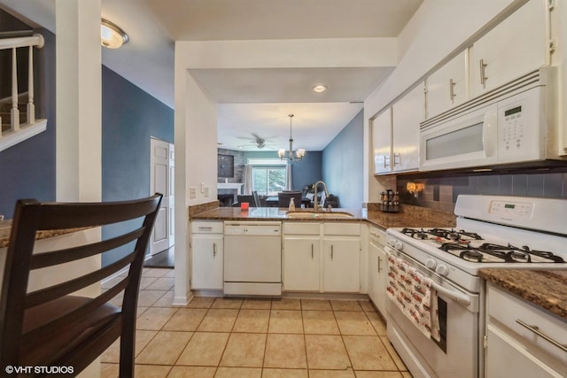 kitchen featuring light tile patterned flooring, sink, white cabinets, white appliances, and backsplash