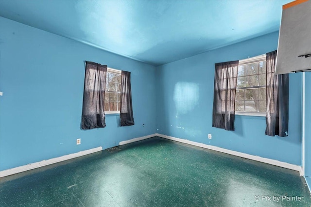 empty room featuring dark floors and baseboards