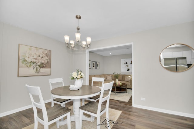 dining space featuring wood-type flooring and a notable chandelier