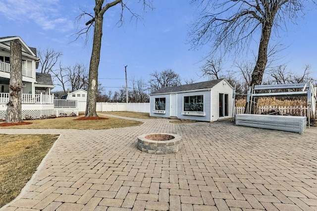 view of patio / terrace with an outdoor structure and a fire pit