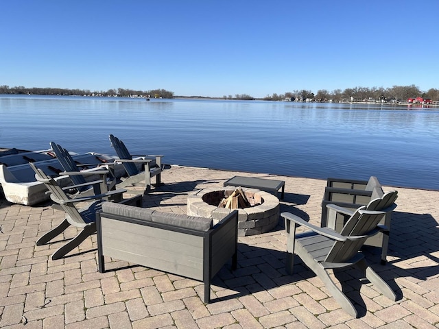 view of patio with a water view and an outdoor fire pit