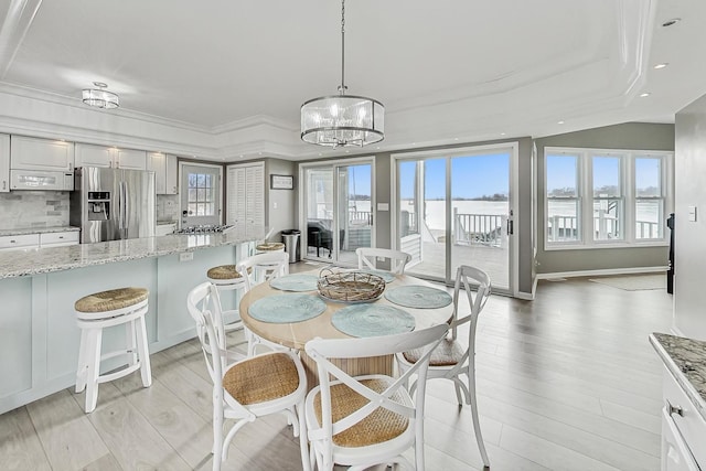 dining room with crown molding, an inviting chandelier, and light hardwood / wood-style flooring