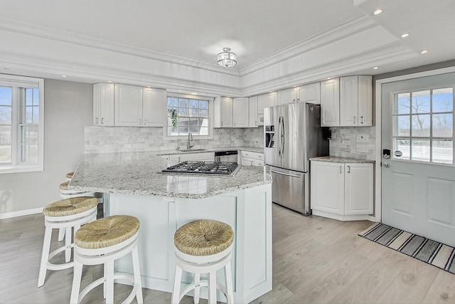 kitchen featuring stainless steel appliances, a breakfast bar, and white cabinets