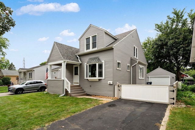 view of front facade featuring a garage, an outdoor structure, and a front lawn