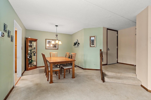 dining area with light colored carpet, a chandelier, and a textured ceiling