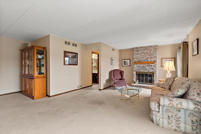 carpeted living room featuring a stone fireplace and a textured ceiling