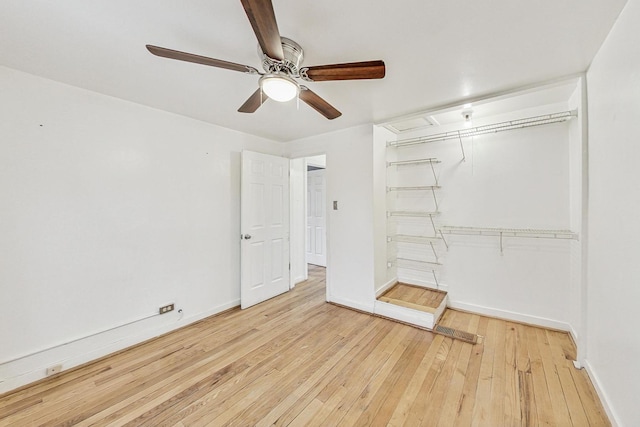 unfurnished bedroom featuring ceiling fan, a closet, and light wood-type flooring