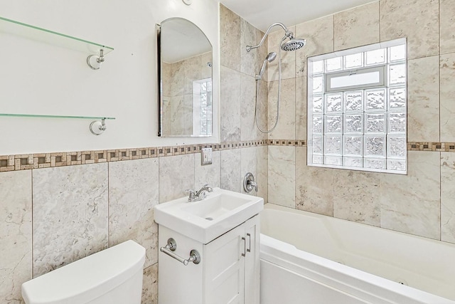 full bathroom with vanity, tiled shower / bath combo, plenty of natural light, and toilet