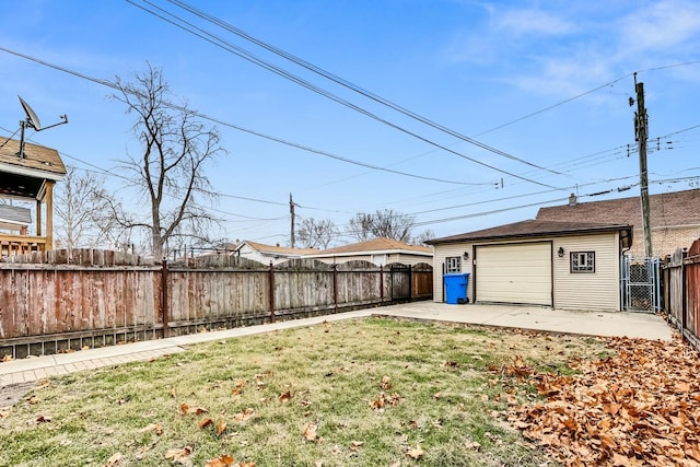 view of yard featuring a garage, a patio, and an outdoor structure