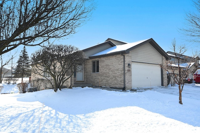 snow covered property with a garage