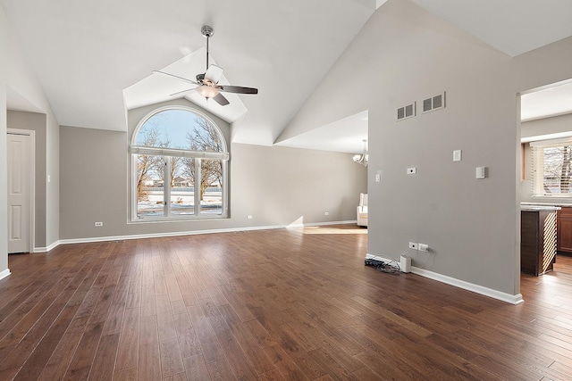 unfurnished living room featuring high vaulted ceiling, dark hardwood / wood-style floors, and ceiling fan with notable chandelier