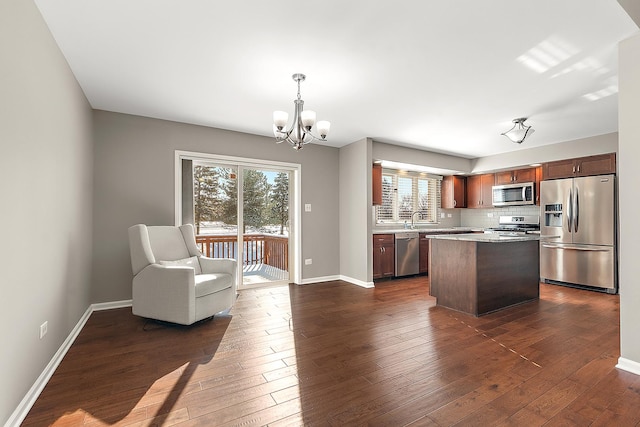 kitchen featuring a center island, a chandelier, dark hardwood / wood-style floors, pendant lighting, and stainless steel appliances