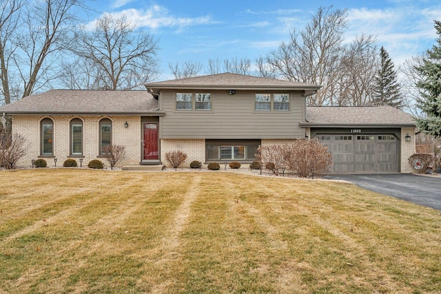 tri-level home featuring a garage and a front lawn