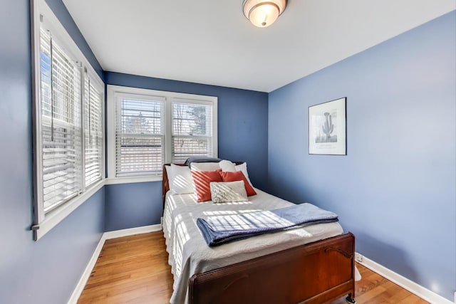 bedroom with light wood-type flooring and baseboards