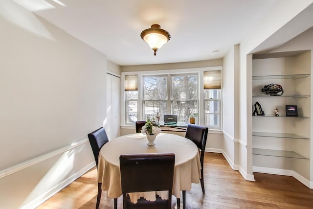 dining space featuring light wood finished floors and baseboards