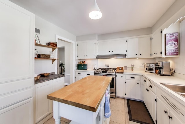 kitchen featuring under cabinet range hood, white cabinets, and stainless steel gas range oven