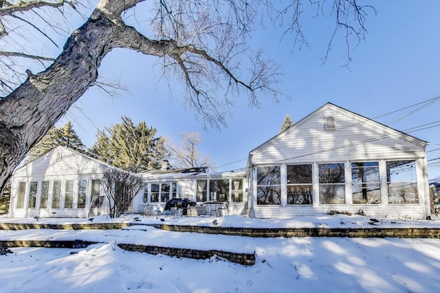 snow covered property featuring a sunroom