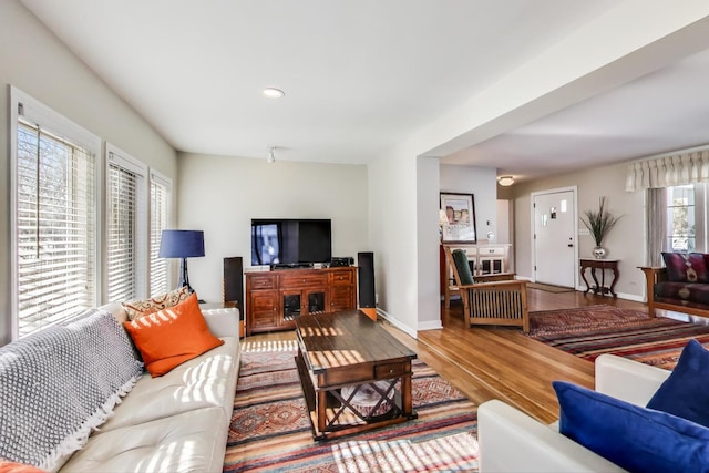 living area featuring baseboards, wood finished floors, and recessed lighting