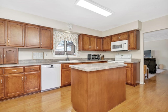 kitchen featuring sink, a center island, white appliances, and light hardwood / wood-style floors