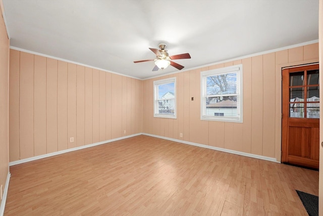 spare room with crown molding, ceiling fan, and light wood-type flooring