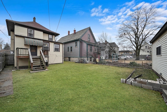 rear view of property featuring a lawn