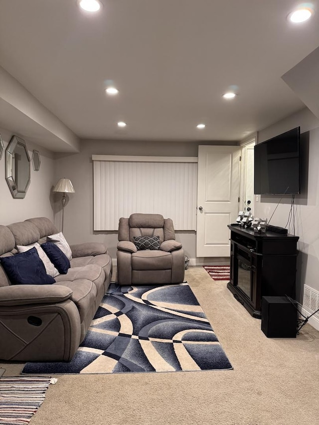 carpeted living area featuring baseboards, visible vents, and recessed lighting