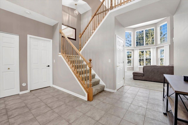 foyer featuring a towering ceiling and light tile patterned floors