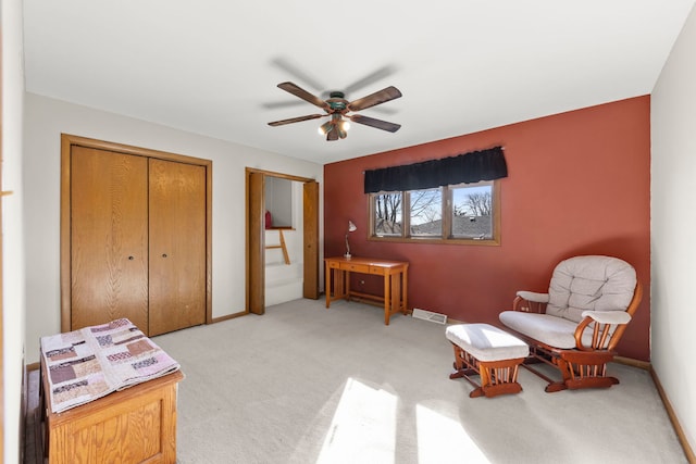 living area with light carpet, ceiling fan, visible vents, and baseboards