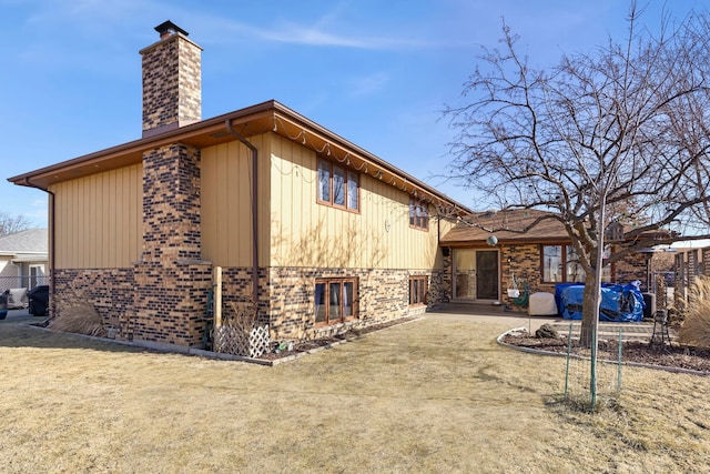 view of home's exterior with a patio area, brick siding, and a chimney