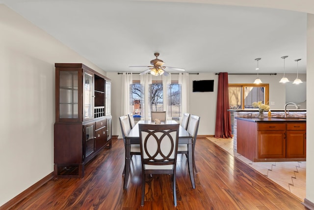 dining area with dark wood-type flooring, ceiling fan, and baseboards