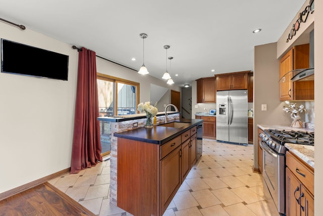 kitchen featuring pendant lighting, a center island with sink, appliances with stainless steel finishes, brown cabinetry, and a sink