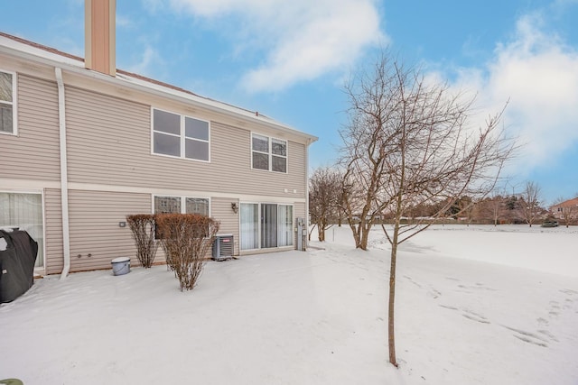 snow covered back of property with central AC unit