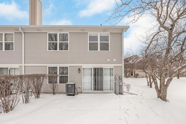 snow covered back of property with central AC